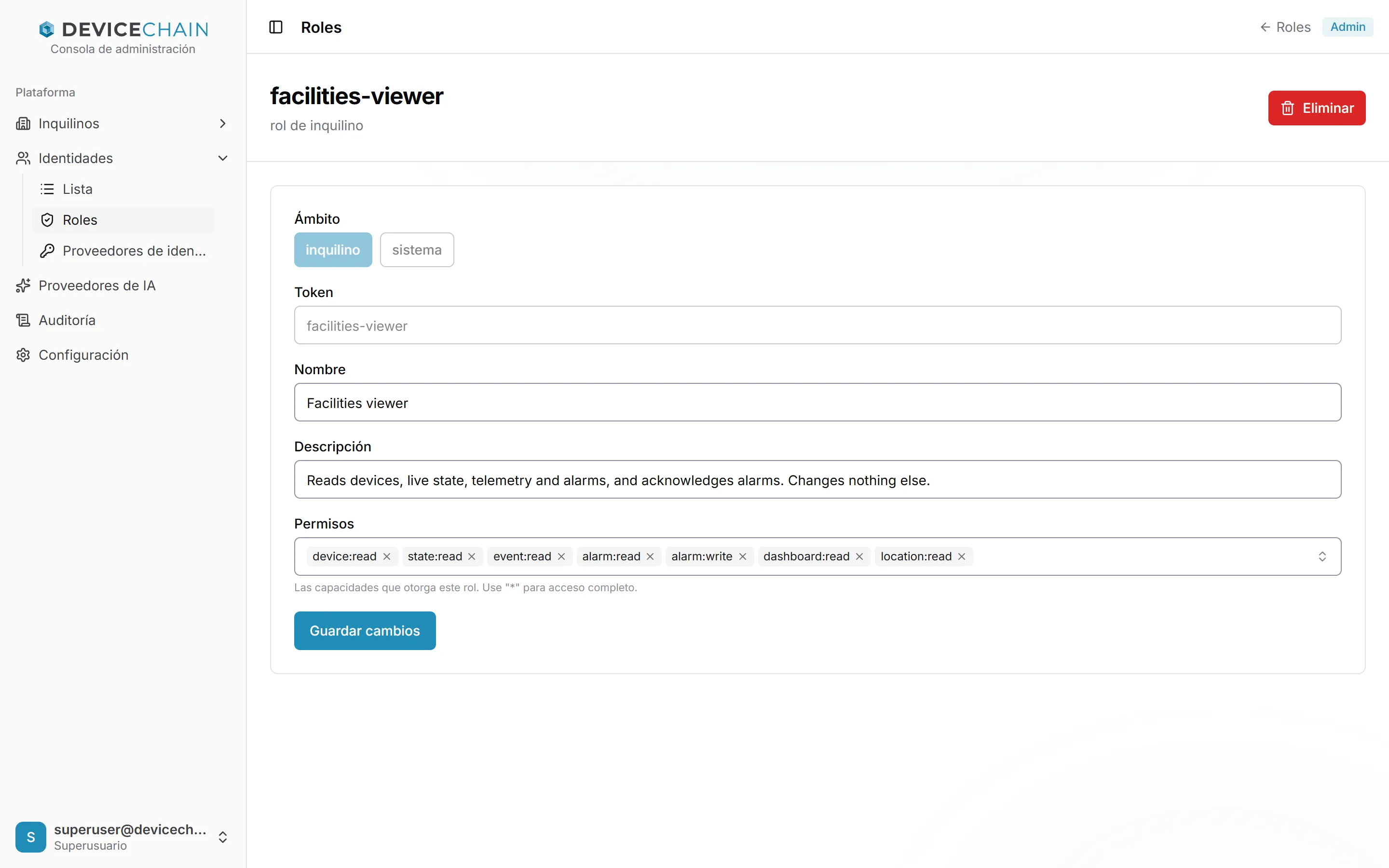El rol de inquilino facilities-viewer. El ámbito muestra inquilino seleccionado y sistema no disponible. El token facilities-viewer en gris, el nombre Facilities viewer y una descripción que dice que lee dispositivos, estado en vivo, telemetría y alarmas, y reconoce alarmas. Los permisos son device:read, state:read, event:read, alarm:read, alarm:write, dashboard:read y location:read. Un botón para guardar los cambios y otro Eliminar.