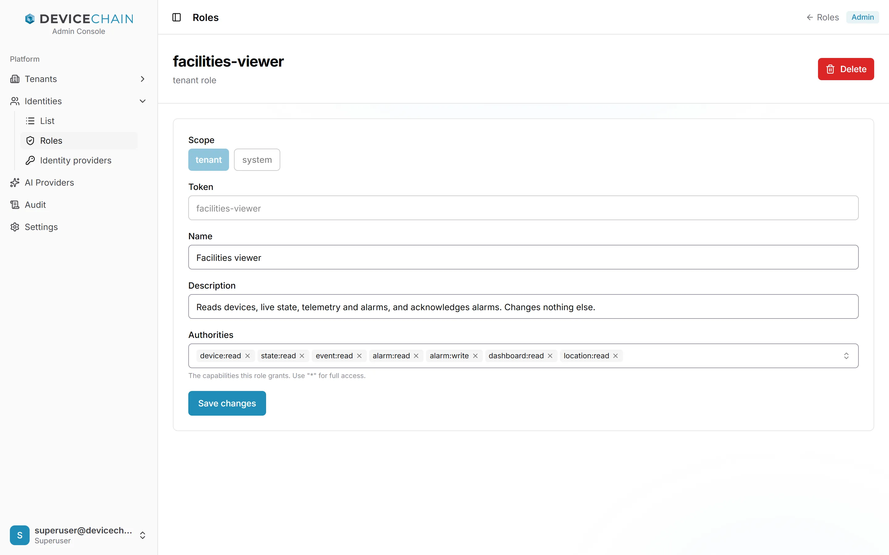 The facilities-viewer tenant role. Scope shows tenant selected and system unavailable. Token facilities-viewer (greyed out), Name Facilities viewer, Description Reads devices, live state, telemetry and alarms, and acknowledges alarms. Changes nothing else. Authorities lists device:read, state:read, event:read, alarm:read, alarm:write, dashboard:read and location:read. A Save changes button and a Delete button.
